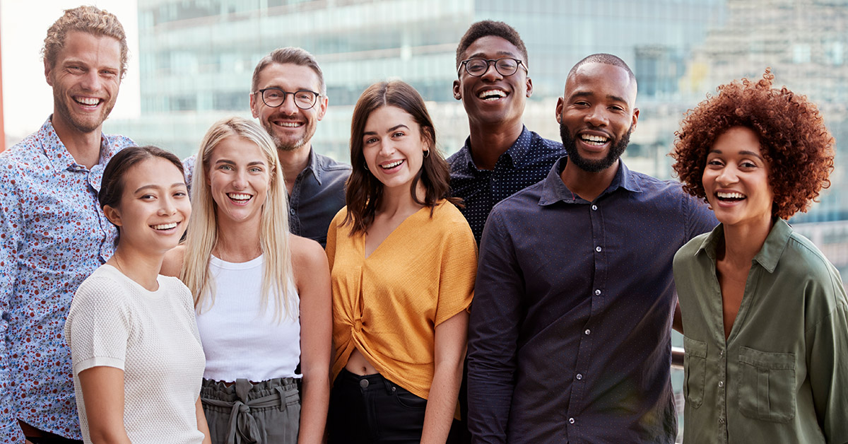 Várias pessoas sorrindo em um ambiente corporativo