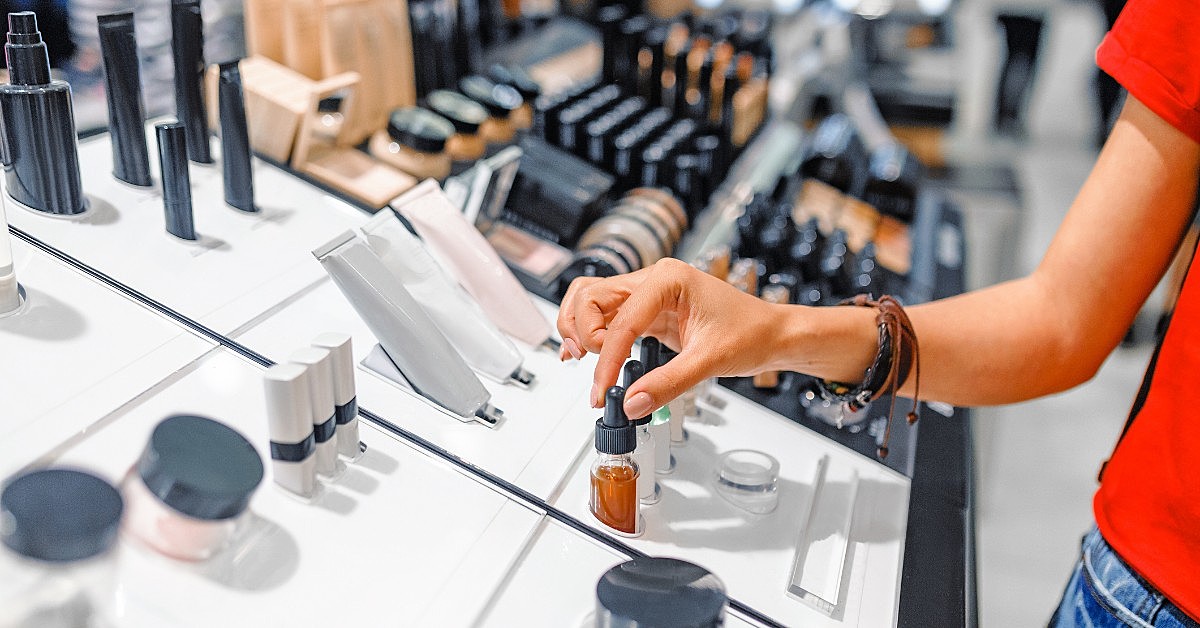 A imagem mostra as mãos de uma mulher manuseando produtos de beleza